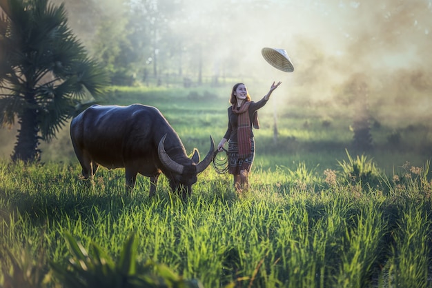 Retrato del granjero tailandés de la mujer joven con el búfalo, campo de Tailandia