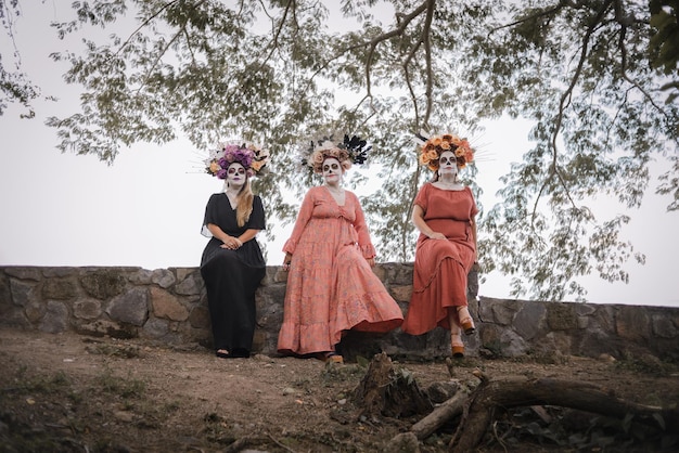 Retrato grupal de tres mujeres con el maquillaje de las catrinas. Maquillaje para dia de muertos.