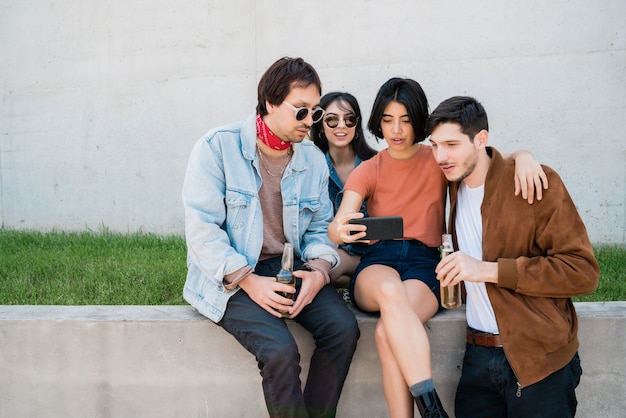 Retrato de un grupo de amigos que se divierten juntos y disfrutan de un buen rato mientras se toman un selfie con el teléfono móvil. Concepto de estilo de vida y amistad.