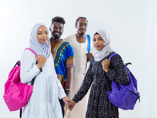 retrato de grupo de estudiantes africanos felices de pie juntos contra niñas de fondo blanco que usan la moda tradicional de hiyab musulmán de sudán