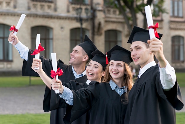 Retrato de grupo de estudiantes celebrando su graduación