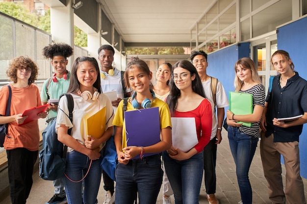 Retrato de un grupo de estudiantes mirando a la cámara jóvenes de diferentes etnias posando f ...