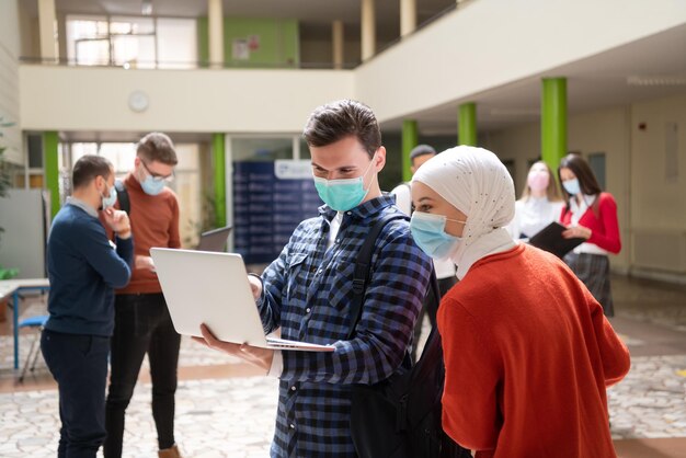 Foto retrato de un grupo de estudiantes multiétnicos en la universidad con máscara de protección facial