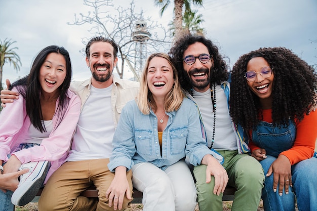 Retrato de un grupo de felices mejores amigos mirando a la cámara jóvenes adultos riendo juntos y