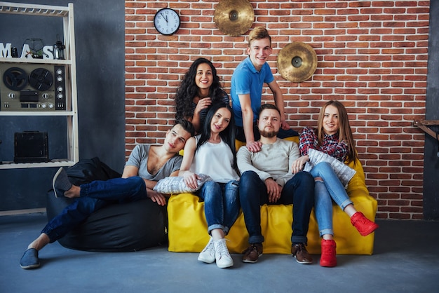 Retrato de grupo de niños y niñas multiétnicos con ropa colorida de moda con un amigo posando en una pared de ladrillo, gente de estilo urbano divirtiéndose, s sobre el estilo de vida de la juventud