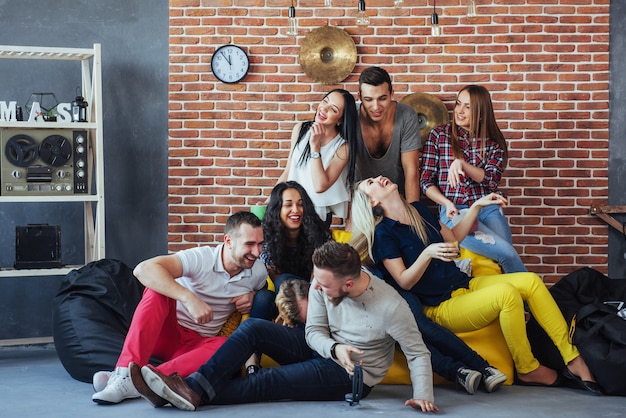 Foto retrato de grupo de niños y niñas multiétnicos con ropa colorida de moda con un amigo posando en una pared de ladrillo, gente de estilo urbano divirtiéndose, s sobre el estilo de vida de la juventud