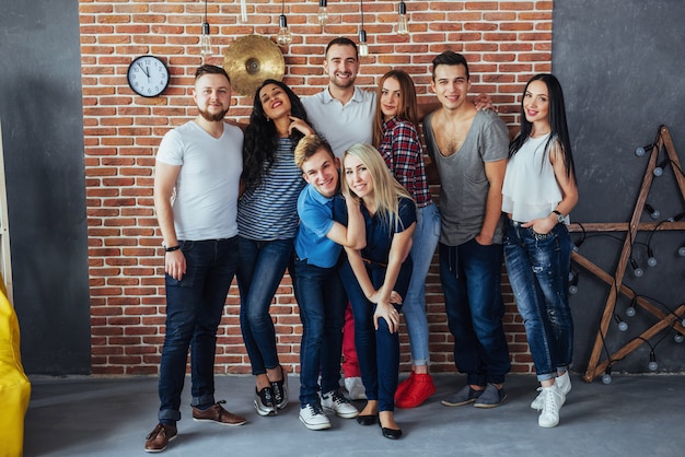 Retrato de grupo de niños y niñas multiétnicos con ropa colorida de moda con un amigo posando en una pared de ladrillo, gente de estilo urbano divirtiéndose, s sobre el estilo de vida de la juventud