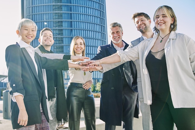 Retrato de un grupo de personas de negocios que se toman de la mano fuera de la oficina Trabajo en equipo y concepto de éxito