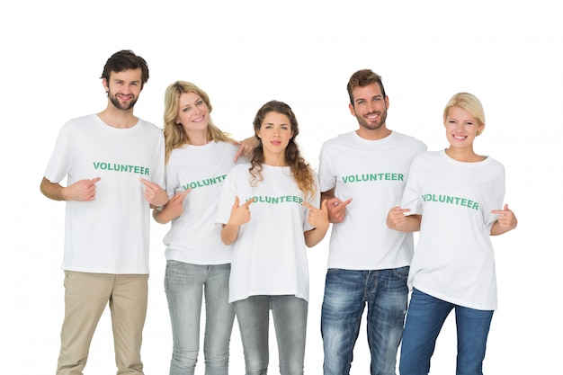 Foto retrato de grupo de voluntarios felices apuntando a sí mismos sobre fondo blanco