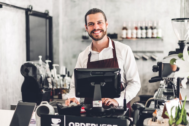 Retrato del guapo barista barbudo detrás del mostrador