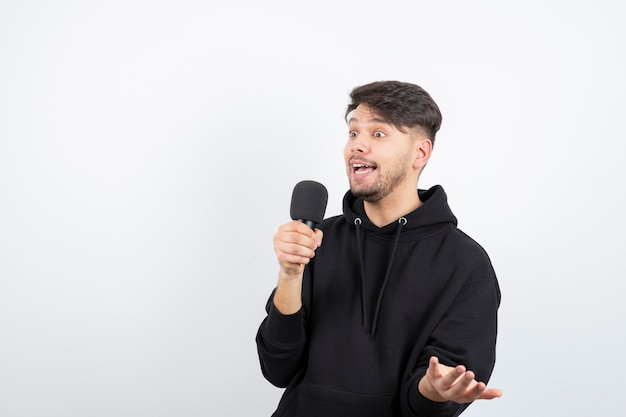 Retrato de guapo cantante cantando golpe en micrófono