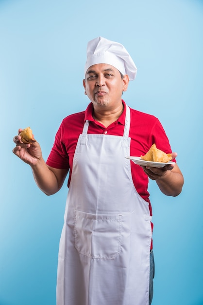 Retrato de guapo chef indio posando mientras realiza actividades