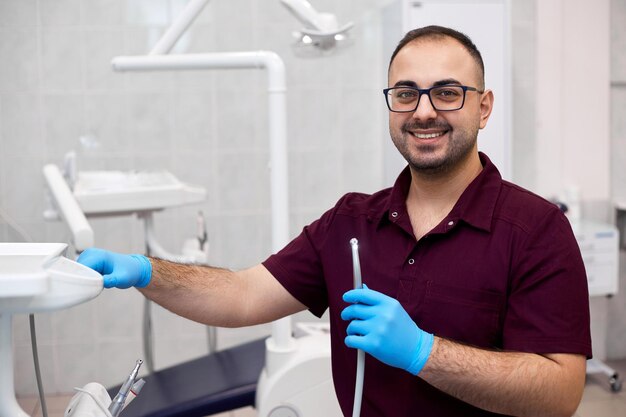 Foto retrato de un guapo dentista profesional en su oficina