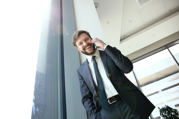 Retrato de guapo empresario confiado sonriente en la oficina