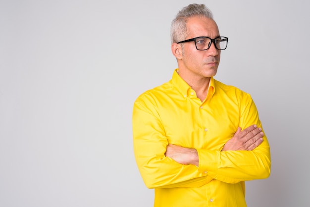 Retrato de guapo empresario persa vistiendo camiseta amarilla sobre blanco