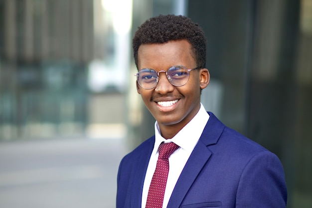 Retrato de guapo feliz seguro joven afroamericano afroamericano empresario al aire libre oficina
