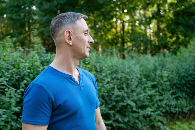 Foto retrato guapo de un hombre con una camiseta azul en una persona del parque