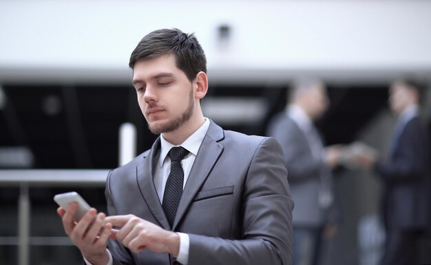 retrato, de, guapo, hombre de negocios, en, oficina borrosa, plano de fondo