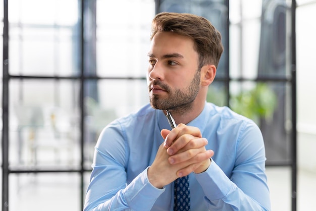 retrato, de, guapo, hombre de negocios, sentado, en, oficina