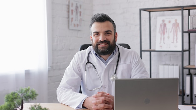 Retrato de guapo médico de correo en consultorio médico