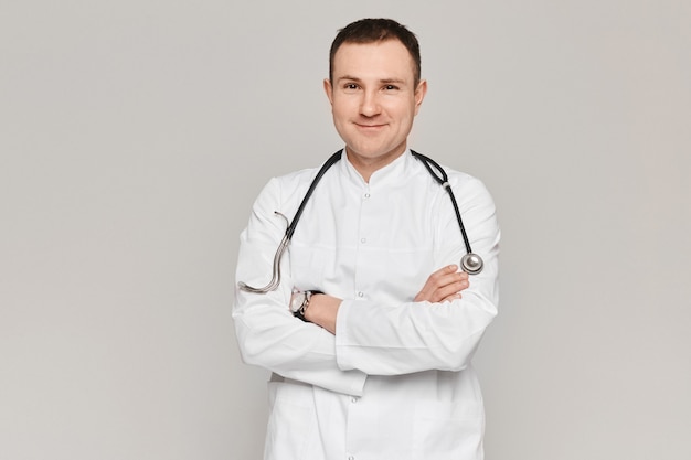 Retrato de guapo médico posando en uniforme médico con estetoscopio