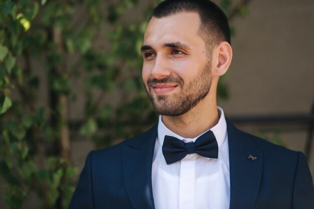 Retrato de guapo novio barbudo en traje azul oscuro