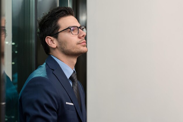 retrato, de, guapo, seguro, joven, hombre de negocios, posición, armamentos cruzaron