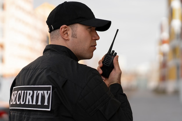 Retrato de guardia de seguridad masculino con estación de radio