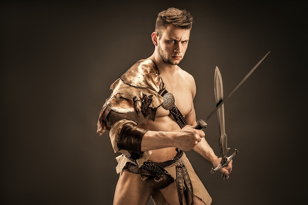 Retrato de guerrero enojado en ropa de cuero con espadas