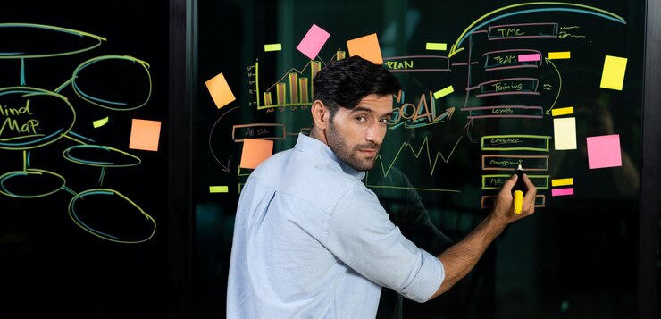 Foto retrato de un hábil hombre de negocios escribiendo una idea de marketing en una pared de vidrio