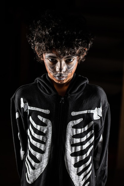 Foto retrato de halloween de niño con la cara pintada por jacko'lantern