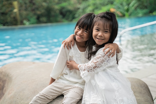 Retrato de hermanas felices representada en un fondo de piscina