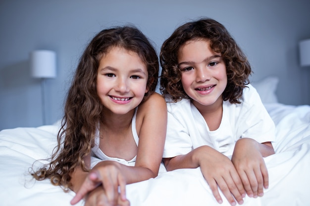 Retrato de hermano y hermana acostada en la cama