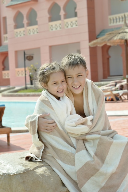 Retrato de hermano y hermana mojados en vacaciones resort ovre pool