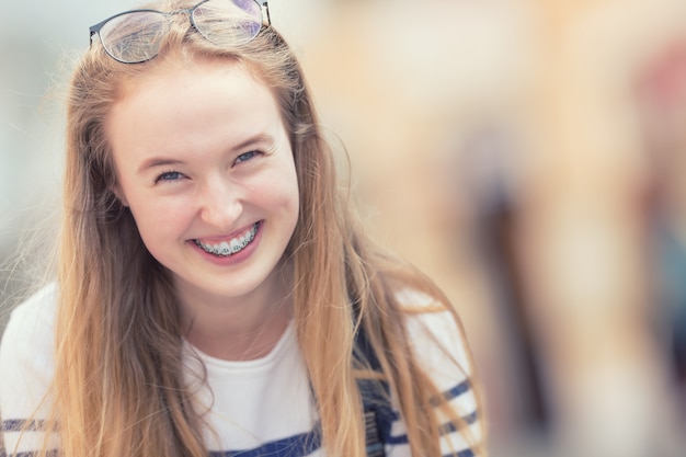 Retrato de una hermosa adolescente sonriente con aparatos dentales.