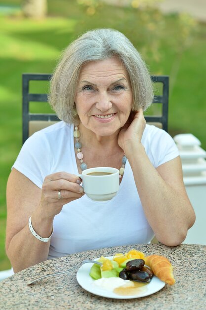 Retrato de hermosa anciana en café