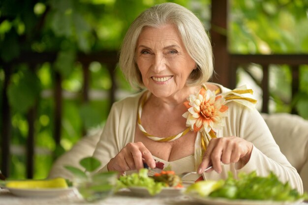 Foto retrato de una hermosa anciana comiendo