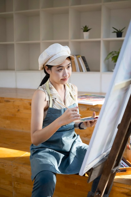 Retrato de una hermosa artista pintando una imagen en el estudio