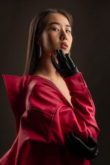 Retrato de una hermosa chica asiática con una chaqueta de cuero roja en un