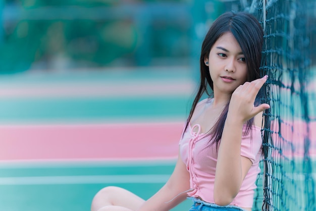 Retrato de una hermosa chica asiática elegante que usa un vestido negro para tomar una foto en una pared de ladrillos Estilo de vida de los adolescentes de Tailandia Concepto feliz de mujer moderna