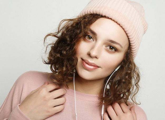 Retrato de una hermosa chica con auriculares escucha música y sonríe