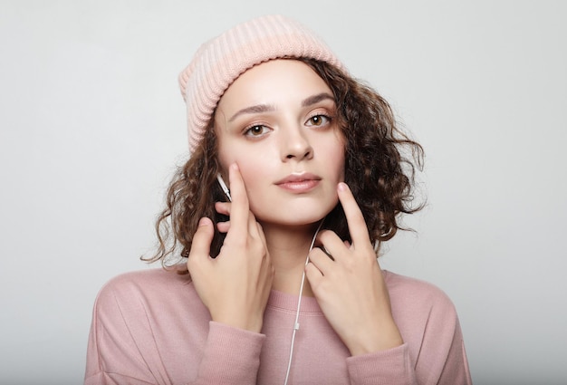 Retrato de una hermosa chica con auriculares escucha música y sonríe