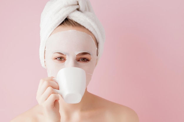 Retrato de una hermosa chica en bata de baño con una taza de té concepto de relajación mujer rubia con bata de baño y toalla en la cabeza después de la ducha Spa mujer en bata de baño y turbante