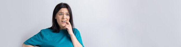 Foto el retrato de una hermosa chica con una camiseta azul mira a un lado con una expresión pensativa y está considerando un plan de acción adicional