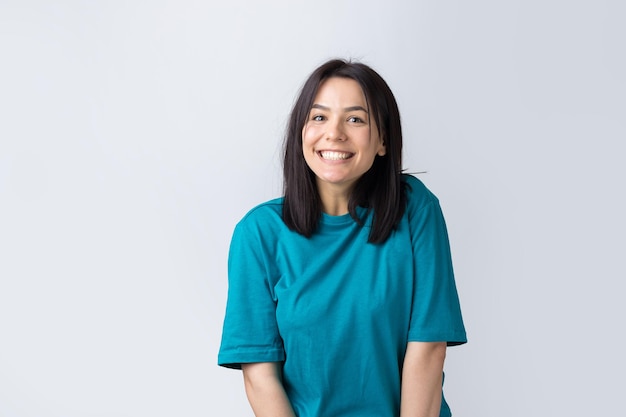 El retrato de una hermosa chica con una camiseta azul mira a un lado con expresión pensativa