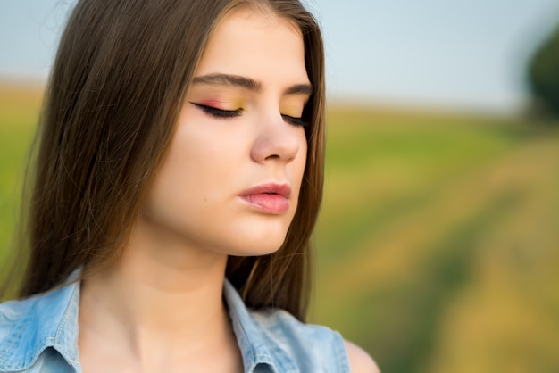 Retrato de una hermosa chica en un campo