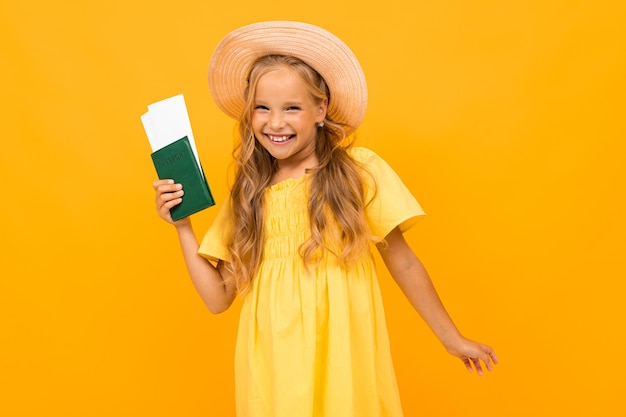 Retrato de hermosa chica caucásica con cabello castaño largo y cara bonita en vestido tiene un pasaporte y boletos