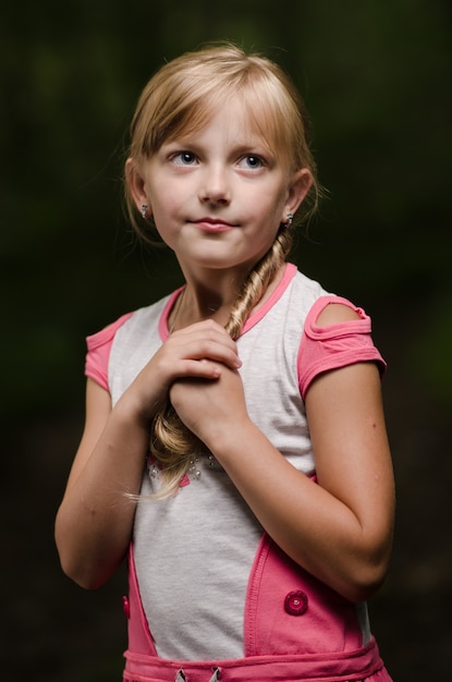 Retrato de una hermosa chica con largo cabello rubio en un bosque