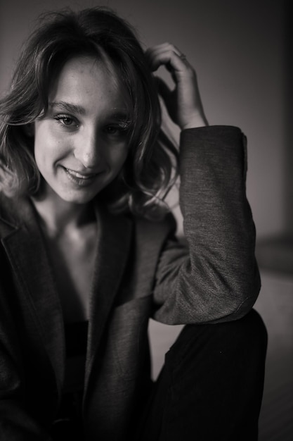 Retrato de una hermosa chica en lencería negra sexy con cabello castaño rizado foto en blanco y negro