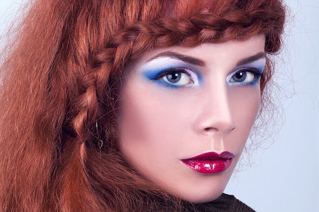 Retrato de una hermosa chica con el pelo rojo.